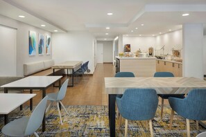 A modern hotel lobby with a seating area, a reception desk, and a kitchenette. - TownePlace Suites by Marriott Tampa Westshore/Airport (Tampa)