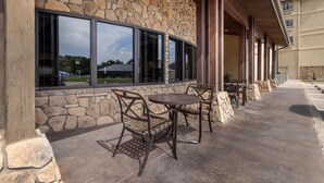 A stone building with large windows and outdoor seating. - Best Western Plus Cimarron Hotel & Suites (Stillwater)