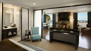 A modern living room with a fireplace, a sofa, and a dining area with a view. - Aurora Hotel (Avalon)