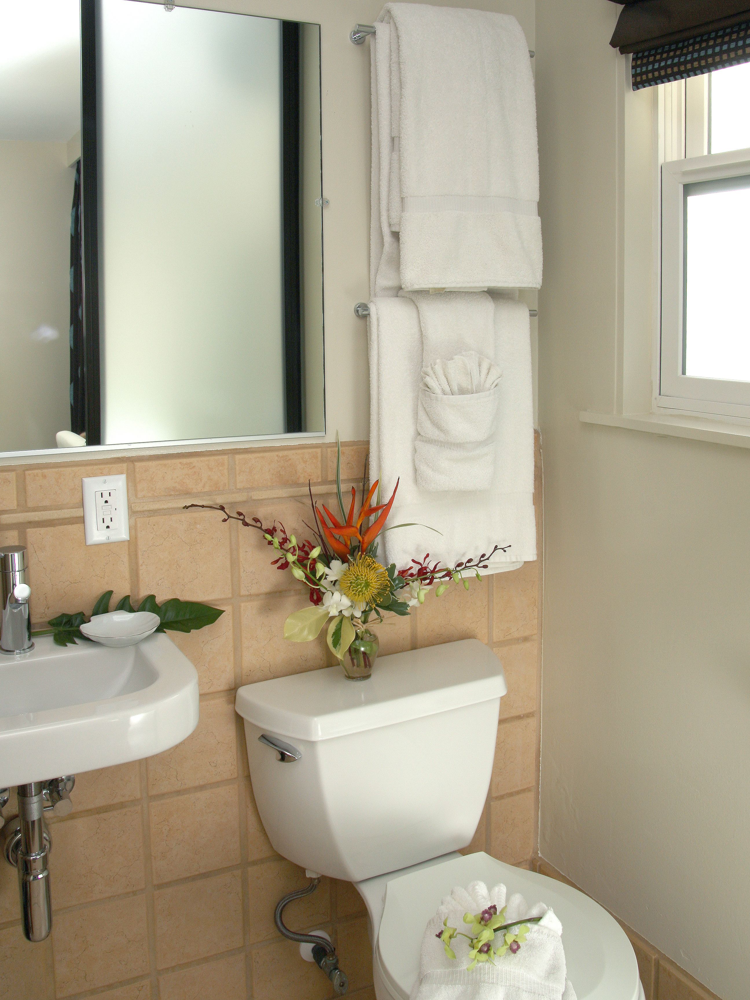 A bathroom with a sink, toilet, and a mirror.