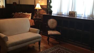 A traditional living room with a sofa, a chair, a lamp, and a small table with a decorative item.