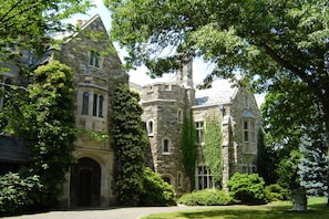 A historic stone building with arched windows and ivy-covered walls. - The Castle at Skylands Manor (Ringwood)