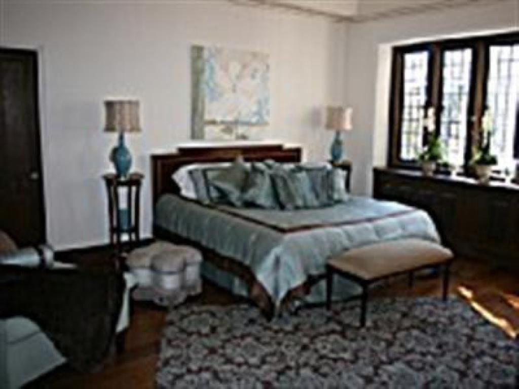 A bedroom with a bed, bedside tables, a window, and a rug.