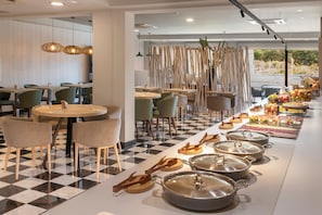 A modern restaurant with a checkered floor, wooden furniture, and a buffet line with various food items. - Salles Hotel Aeroport de Girona (Riudellots de la Selva)
