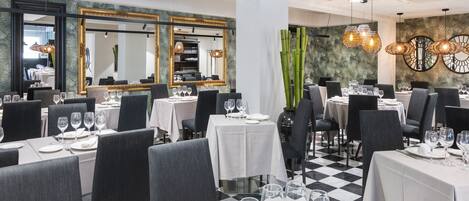 A restaurant with multiple tables set for dining, featuring a checkered floor and modern decor.