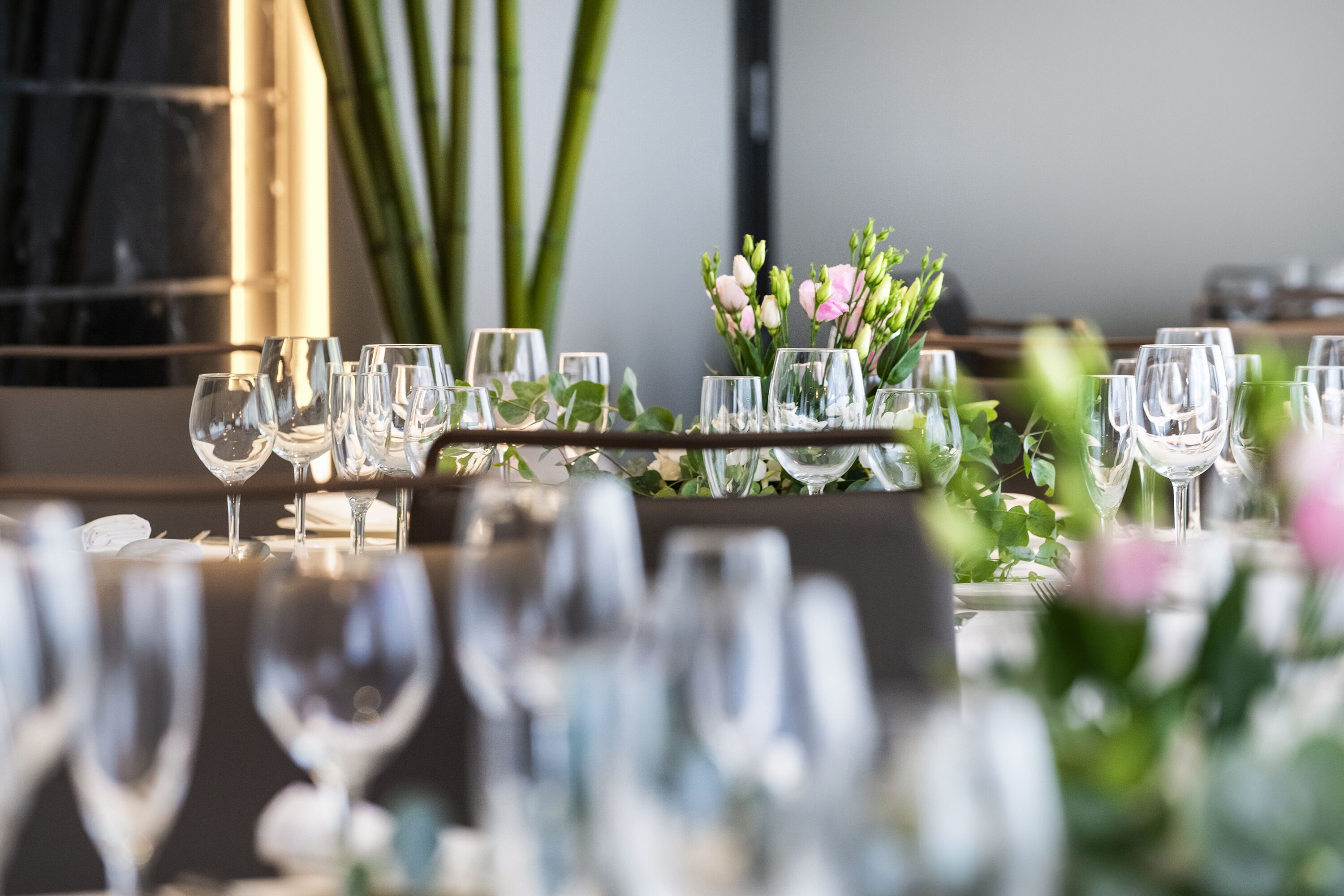 Una mesa dispuesta con varias copas de vino y un centro de flores.