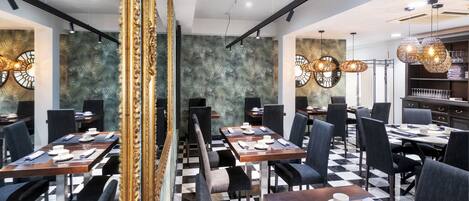 A restaurant with checkered flooring, black and white decor, and modern lighting fixtures.