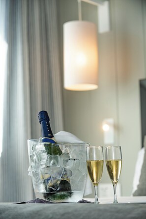 A room with a bed, a bedside table, a nightstand, a lamp, and a window with curtains. - Salles Hotel Aeroport de Girona (Riudellots de la Selva)