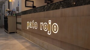 A reception desk with a sign reading "pato rojo" and a marble counter. - Pato Rojo (Punta Umbría)