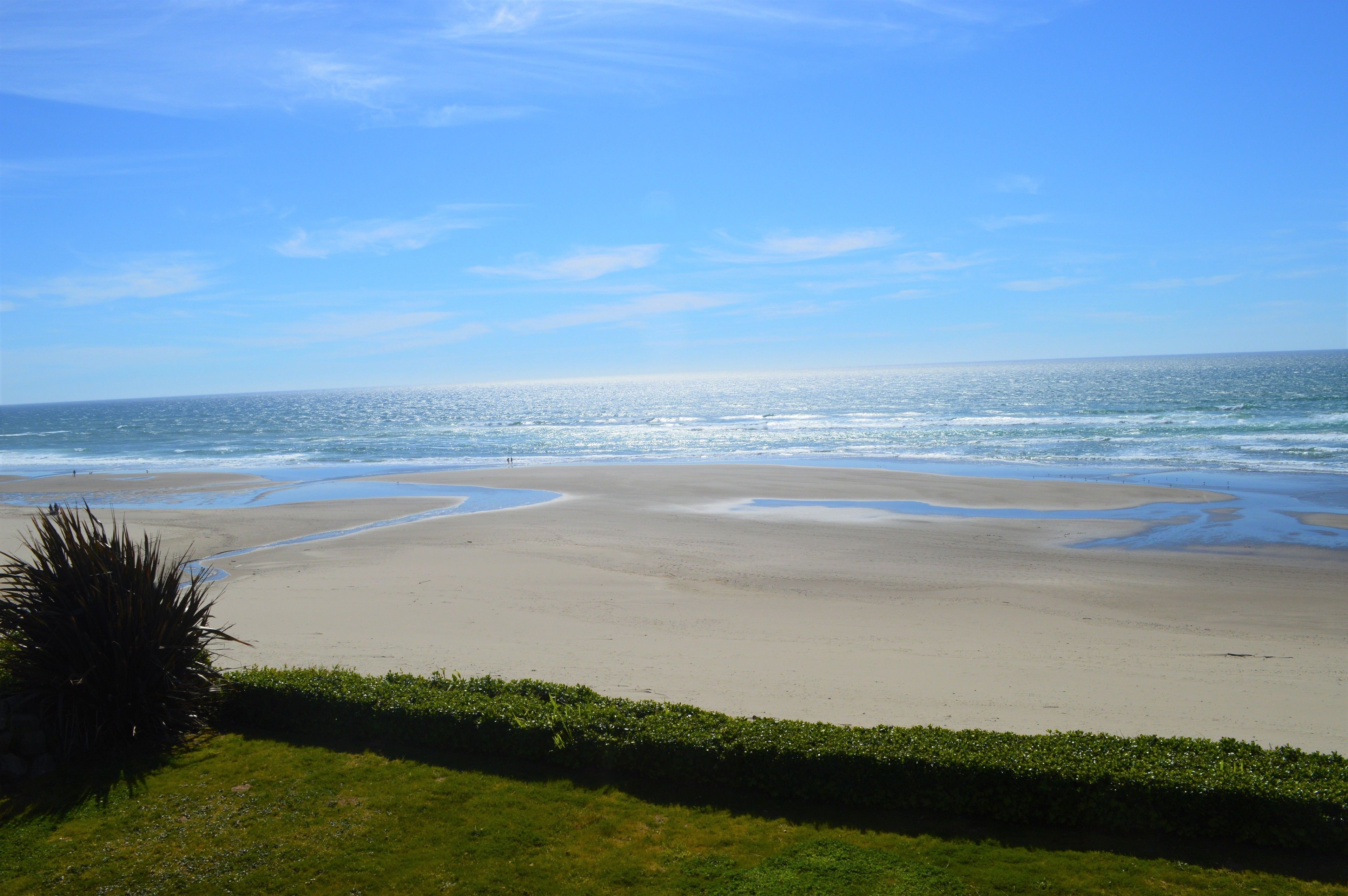 Een strand met een heldere lucht en een kalme zee.
