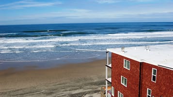 Vista da praia com um edifício de tijolos vermelhos em primeiro plano.