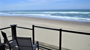 A beach view from a balcony with chairs and a railing. - Beachfront Manor Hotel (Lincoln City)
