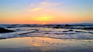 A beach with waves and a sunset. - Beachfront Manor Hotel (Lincoln City)