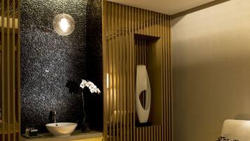 Un spa moderno con un mostrador de recepción de madera, un jarrón grande y una camilla de masaje.