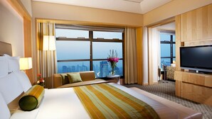 A hotel room with a large bed, a television, a desk, and a view of the city. - Ningbo Marriott Hotel (Ningbo)