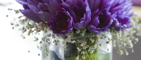 Un bouquet de fleurs violettes dans un vase en verre transparent.