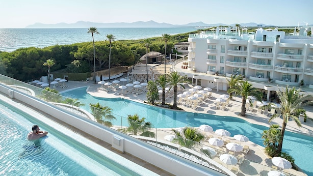A resort with a large pool, lounge chairs, and a view of the sea. - Iberostar Selection Albufera Park - All Inclusive (Muro)