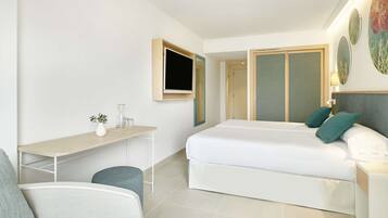 A modern hotel room with a bed, a desk, a chair, and a TV.