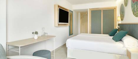 Una habitación de hotel moderna con una cama, un escritorio, una silla y un televisor.