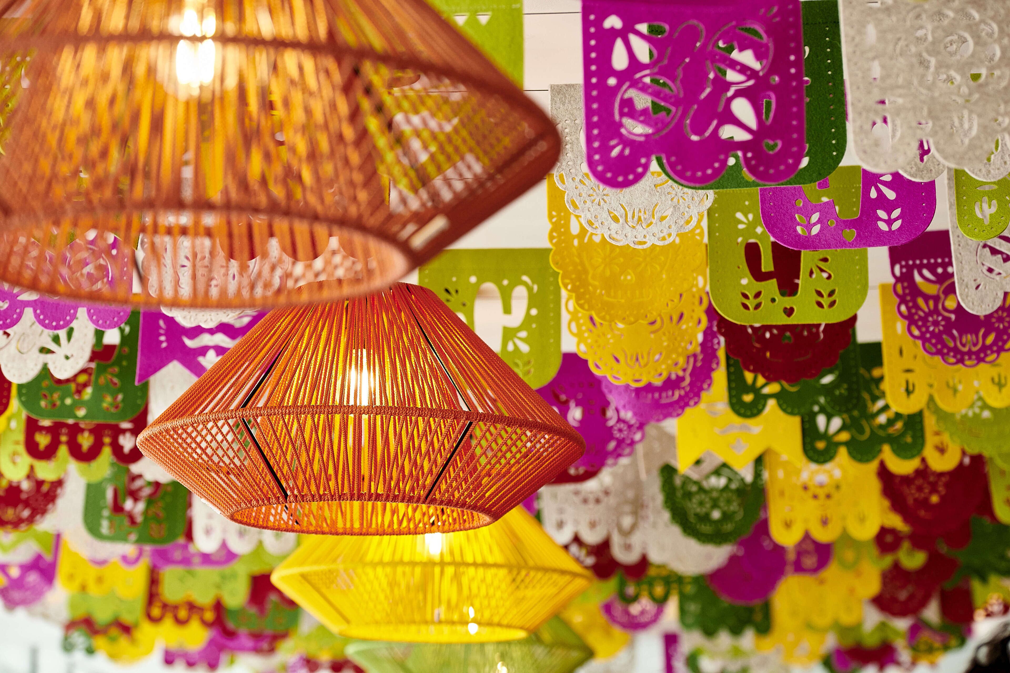 A room with hanging paper lanterns and colorful paper decorations.