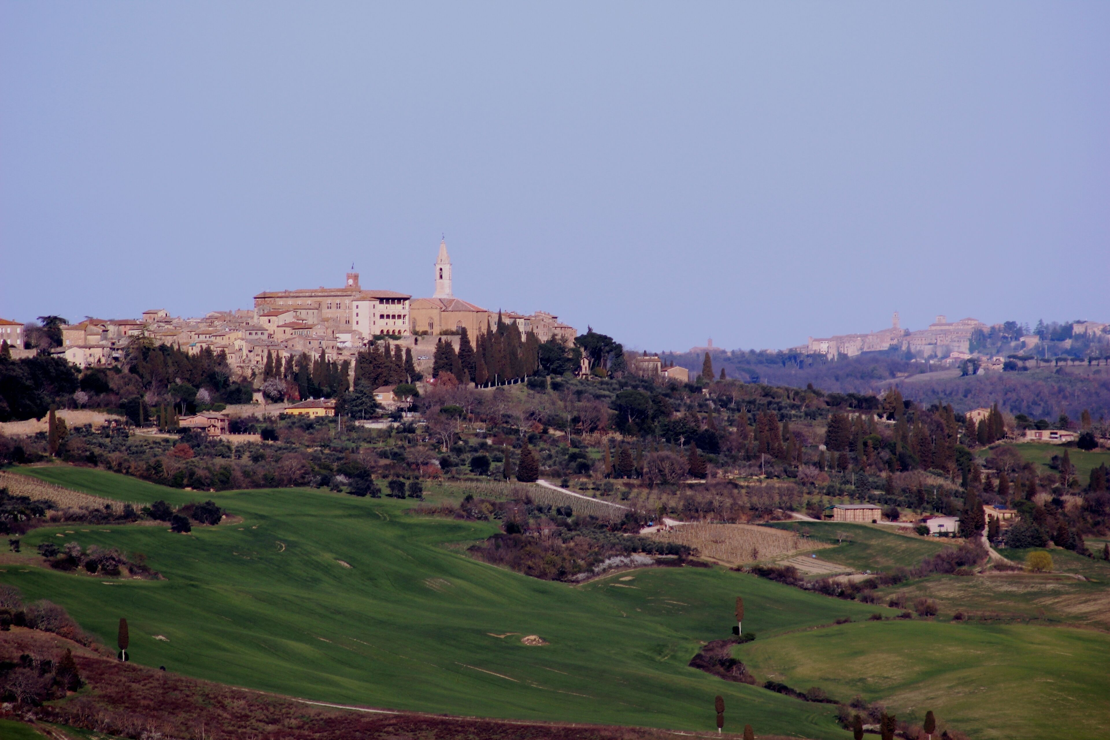 A historic town with a prominent church and surrounding green fields.
