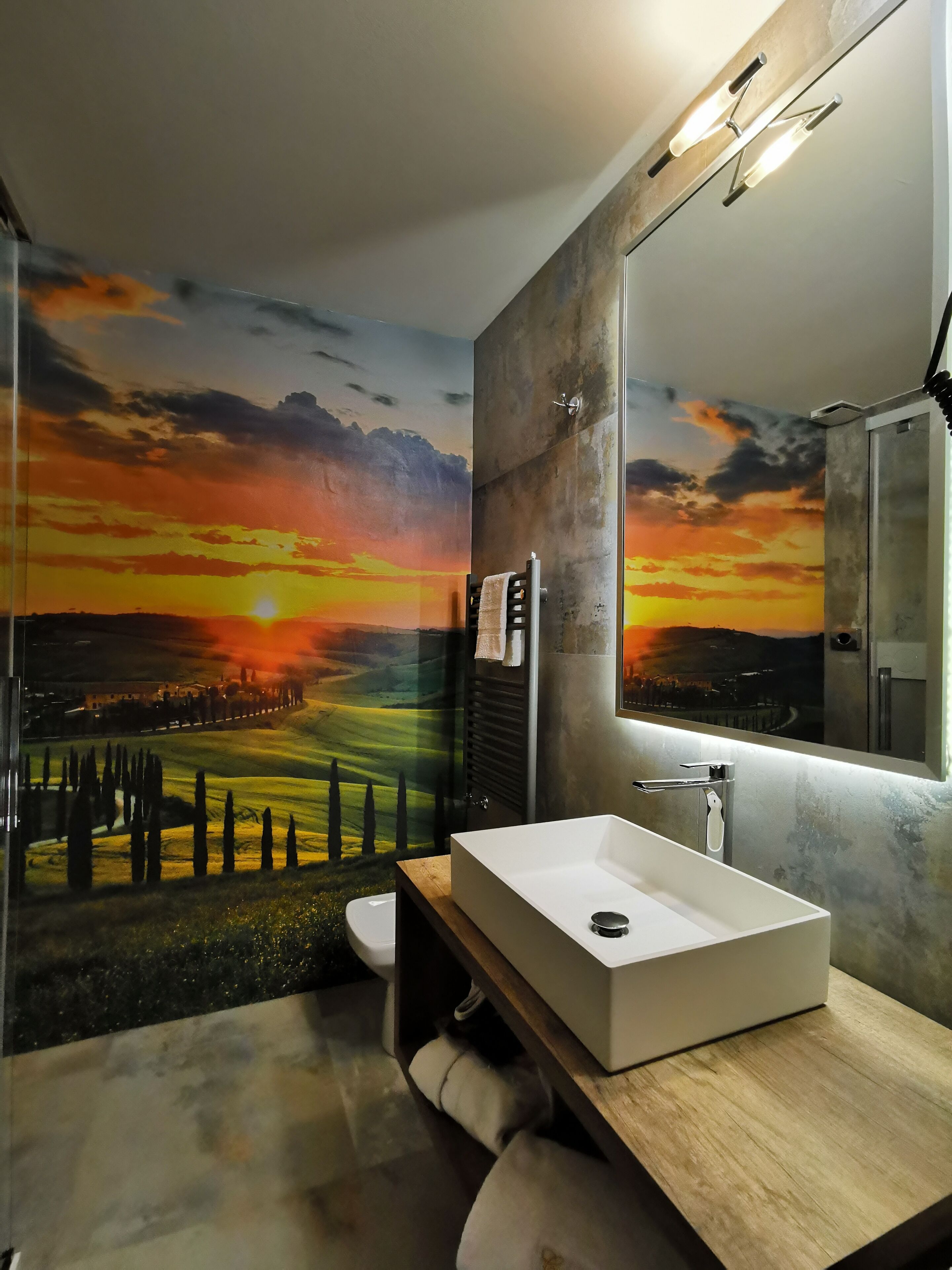 A modern bathroom with a large mirror, a rectangular sink, and a shower.