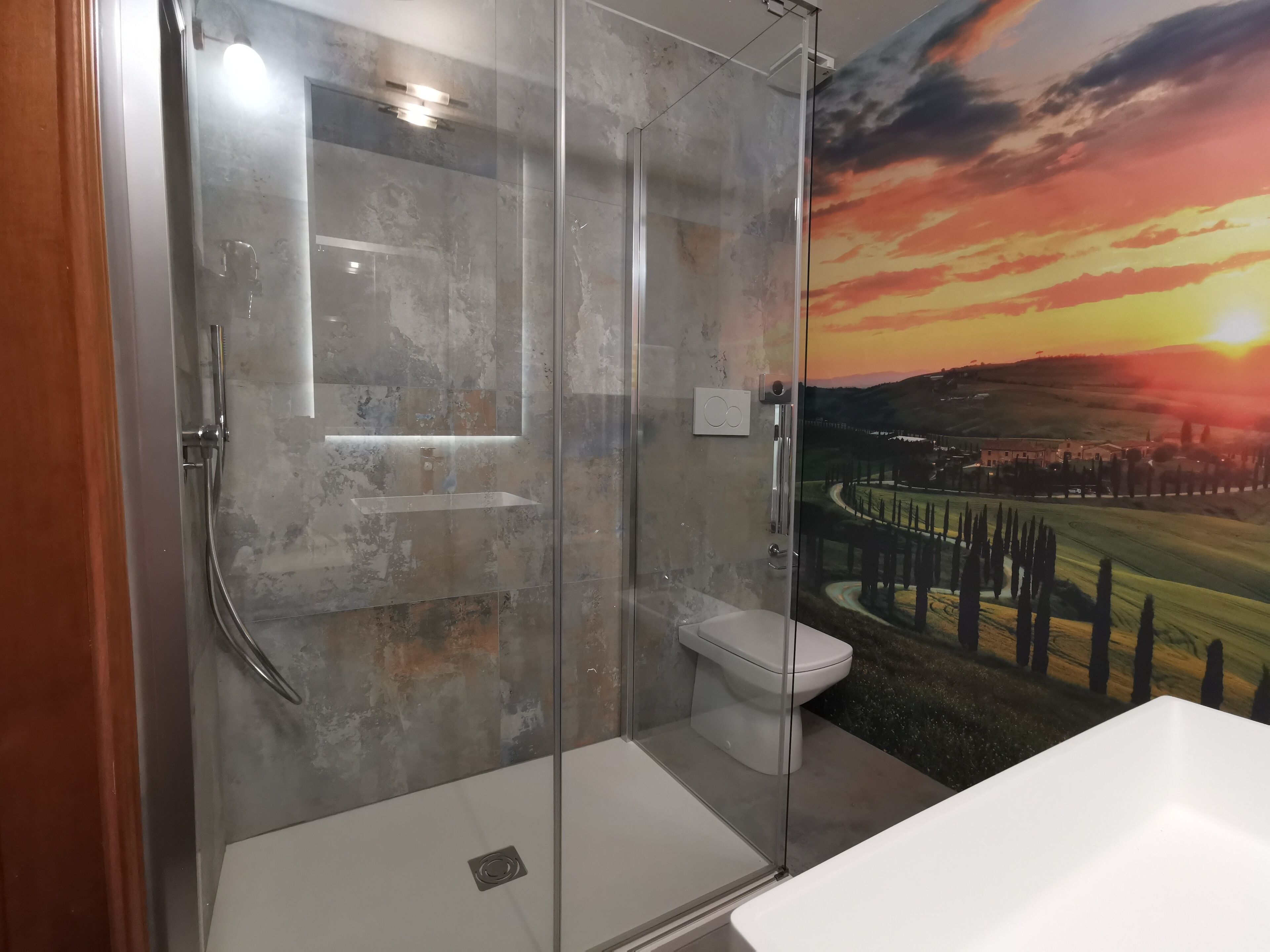 A modern bathroom with a glass shower enclosure, a toilet, and a bathtub.