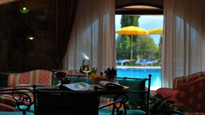 A cozy indoor seating area with a view of a swimming pool.