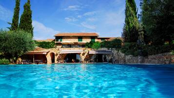 Een seizoensgebonden buitenzwembad, parasols voor strand/zwembad