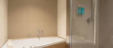 Een moderne badkamer met een douchecabine van glas, een vrijstaand bad en een toilet.
