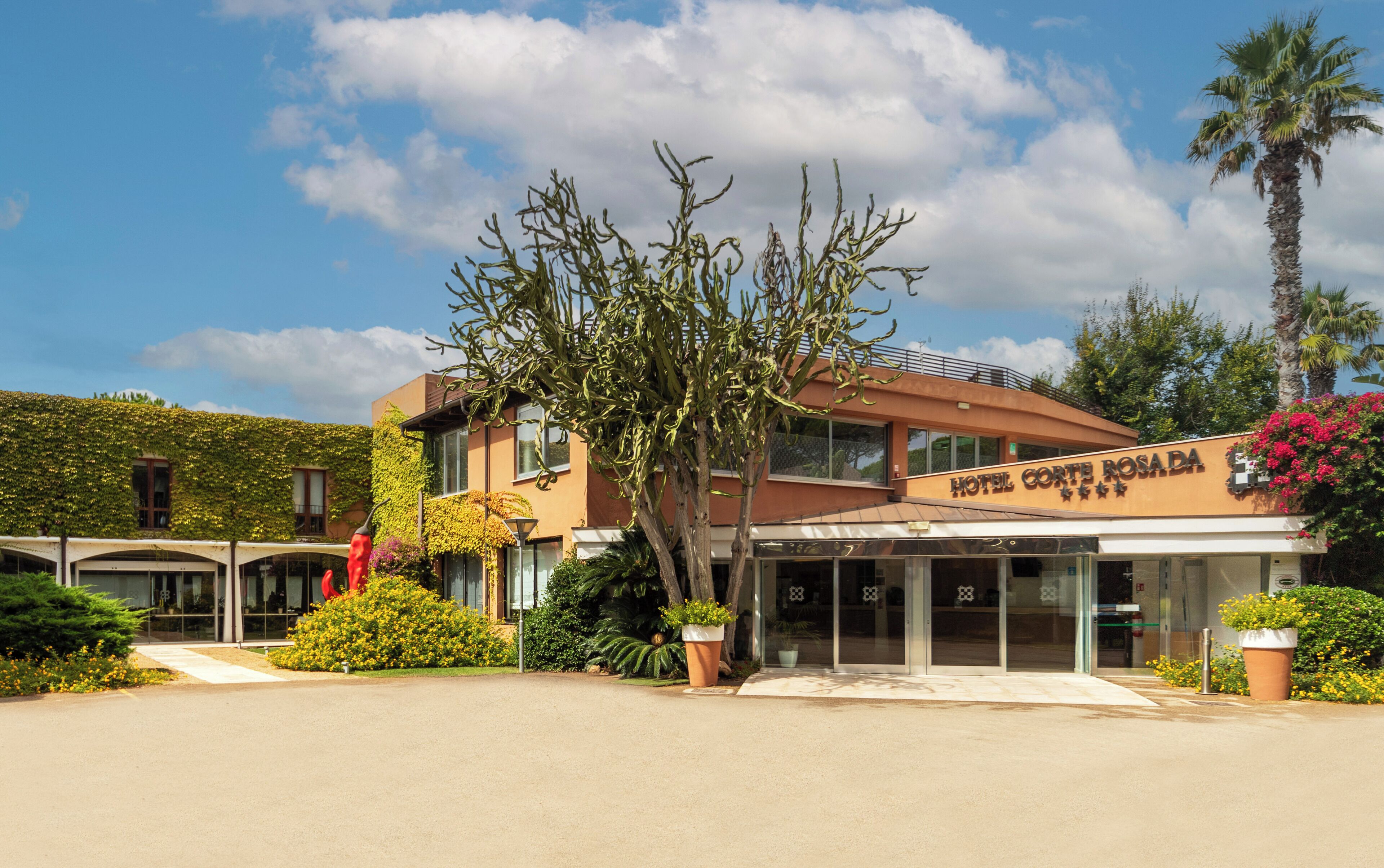 Un hôtel à la façade moderne, doté d’un hall d’entrée abrité et offrant une vue sur un ciel dégagé.