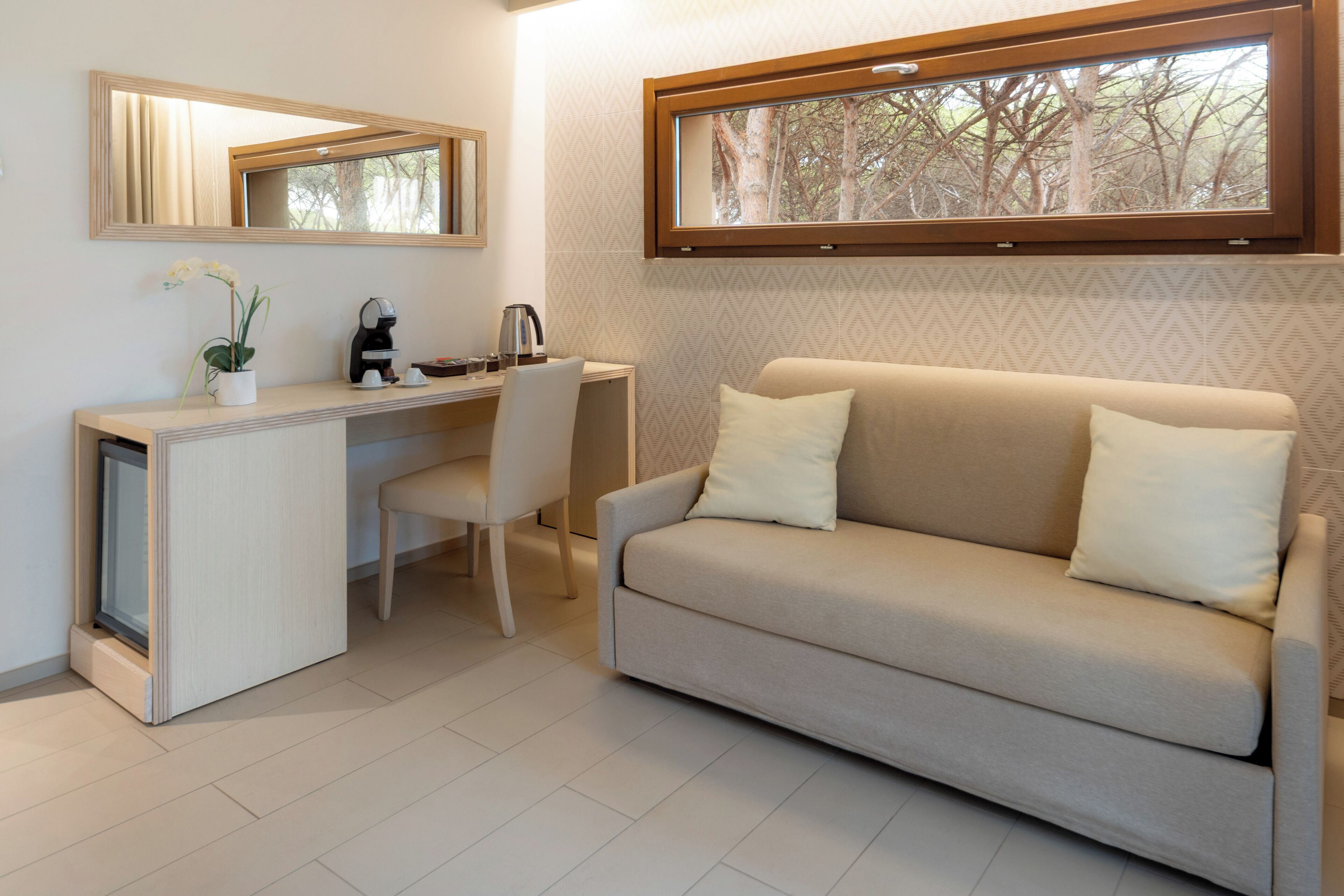 Una habitación pequeña con escritorio, silla y sofá.