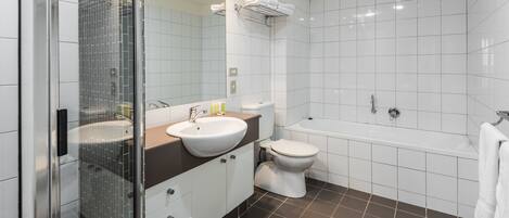 A modern bathroom with a glass shower enclosure, a white sink, a toilet, and a bathtub.