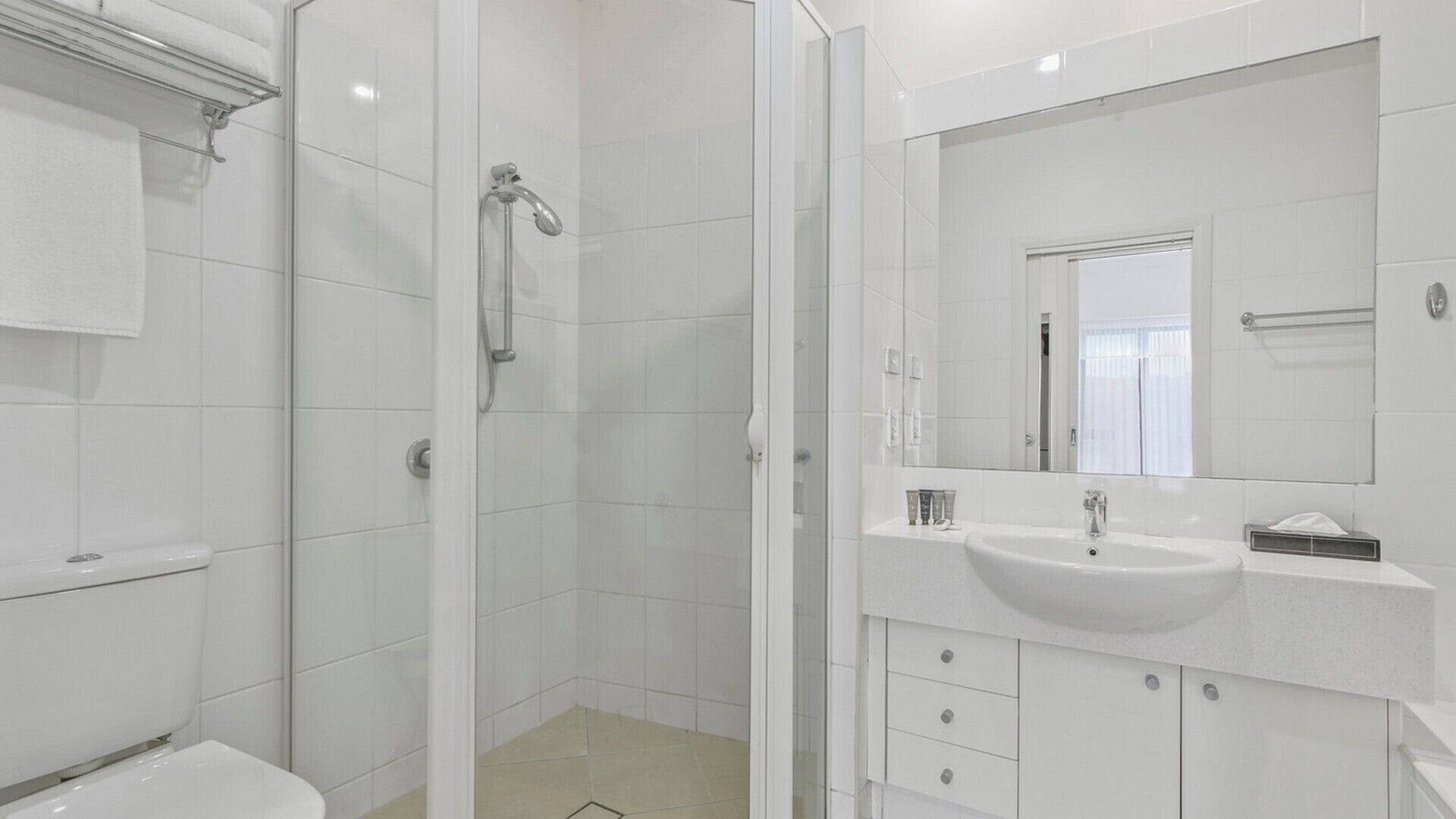 A modern bathroom with a shower, toilet, and sink.