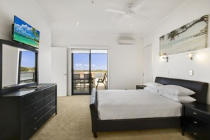 A bedroom with a bed, a dresser, a television, and a painting. - The Esplanade Resort and Spa (Lakes Entrance)