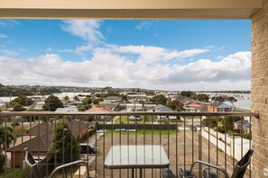 A balcony with a view of a residential area and a body of water. - The Esplanade Resort and Spa (Lakes Entrance)