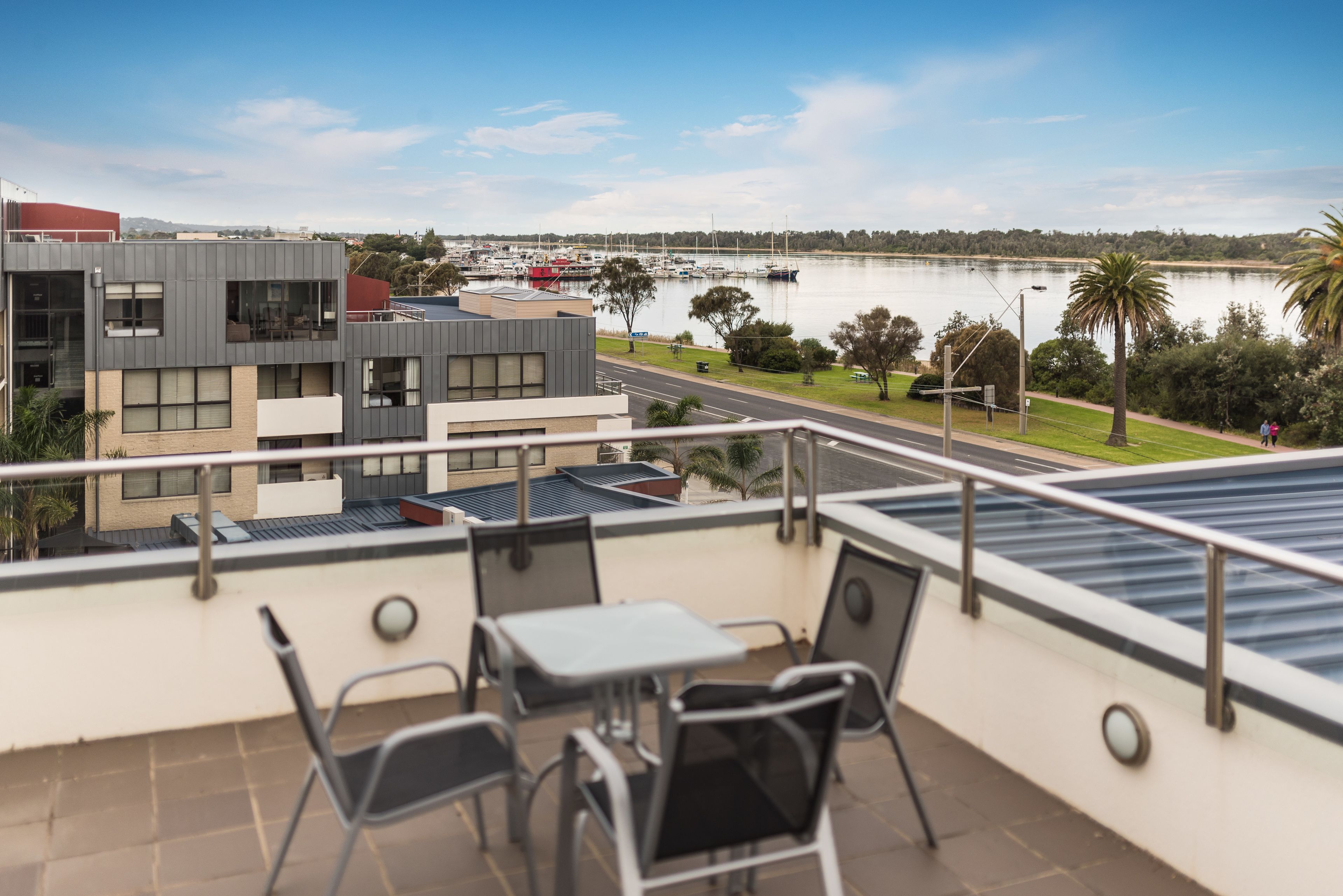 A balcony with a view of a marina and buildings across the water.