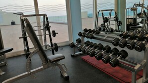 A gym with weightlifting equipment, including dumbbells and a bench press. - Gran Hotel del Coto (Almonte)