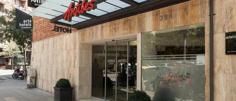 A hotel entrance with a glass facade, a canopy, and a sign reading "Antibes."