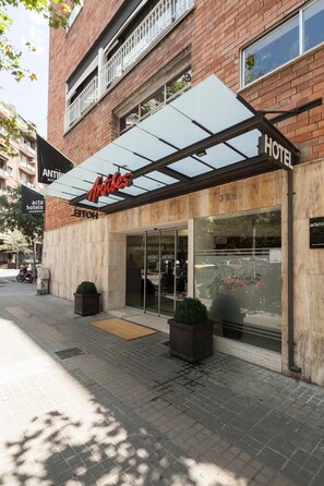 A hotel entrance with a glass facade, a canopy, and a sign reading "Antibes."