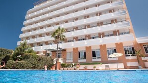 A multi-story hotel with a pool area in front. - Pato Amarillo (Punta Umbría)
