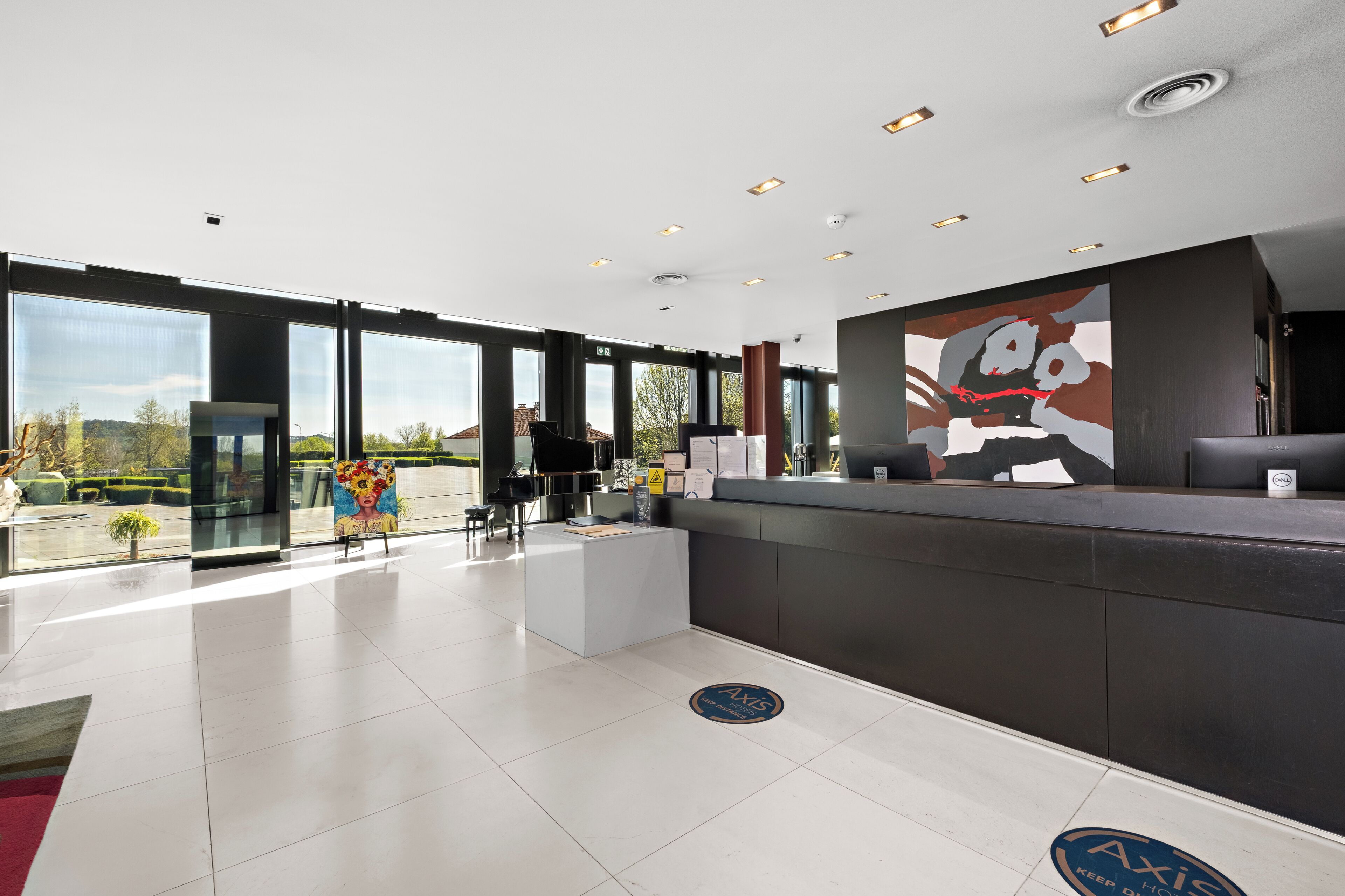 A modern reception area with a large window, a reception desk, and a digital screen.