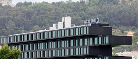 Un hotel moderno con techo plano y un letrero que dice "AXIS HOTEL".