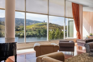 A spacious living room with a large window offering a view of a river and hills. - Crisol Régua Douro (Peso da Régua)
