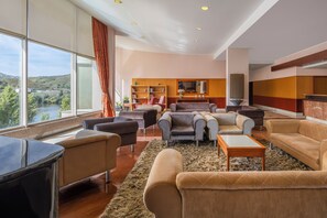 A spacious living room with a large window, a fireplace, and a view of a river. - Crisol Régua Douro (Peso da Régua)