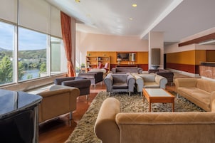 Amplia sala de estar con un ventanal grande, una chimenea y vistas a un río.