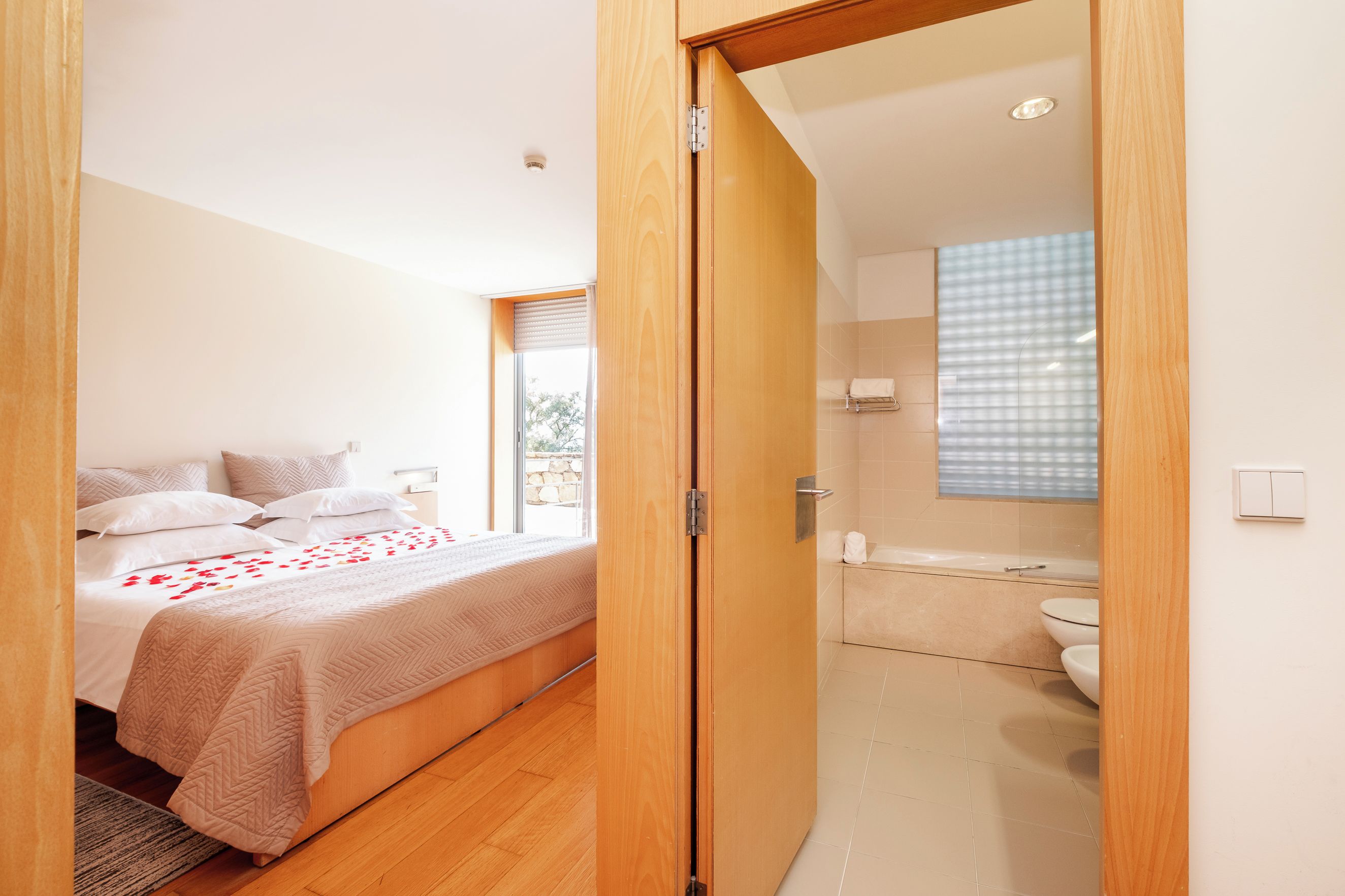 A bedroom with a bed, a bathroom with a bathtub, and a toilet.