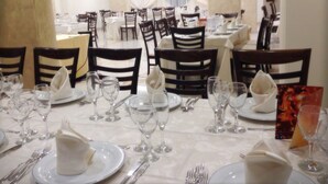 A dining area with tables set for a formal meal, featuring white tablecloths, neatly arranged cutlery, and wine glasses. - Cliffs Hotel (Joppolo)