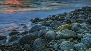 A rocky shoreline with a sunset over the ocean. - Cliffs Hotel (Joppolo)