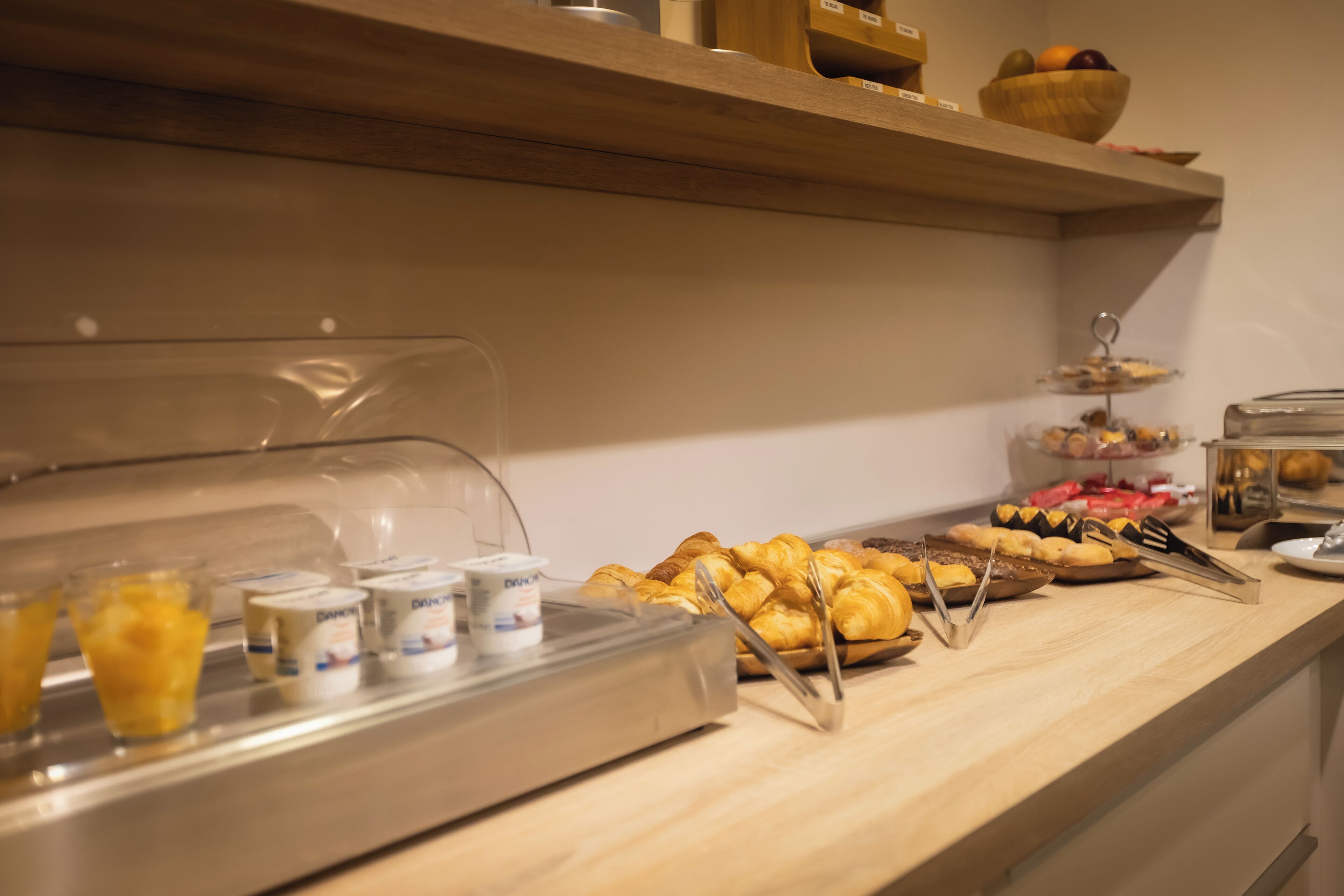 Un mostrador de buffet con diversos alimentos y recipientes.